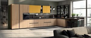 Lacado mate Amarillo Mostaza para los muebles altos con puerta inclinada, en combinación con los muebles altos abiertos de metal color Antracita, combinados con enchapado Roble Grano.